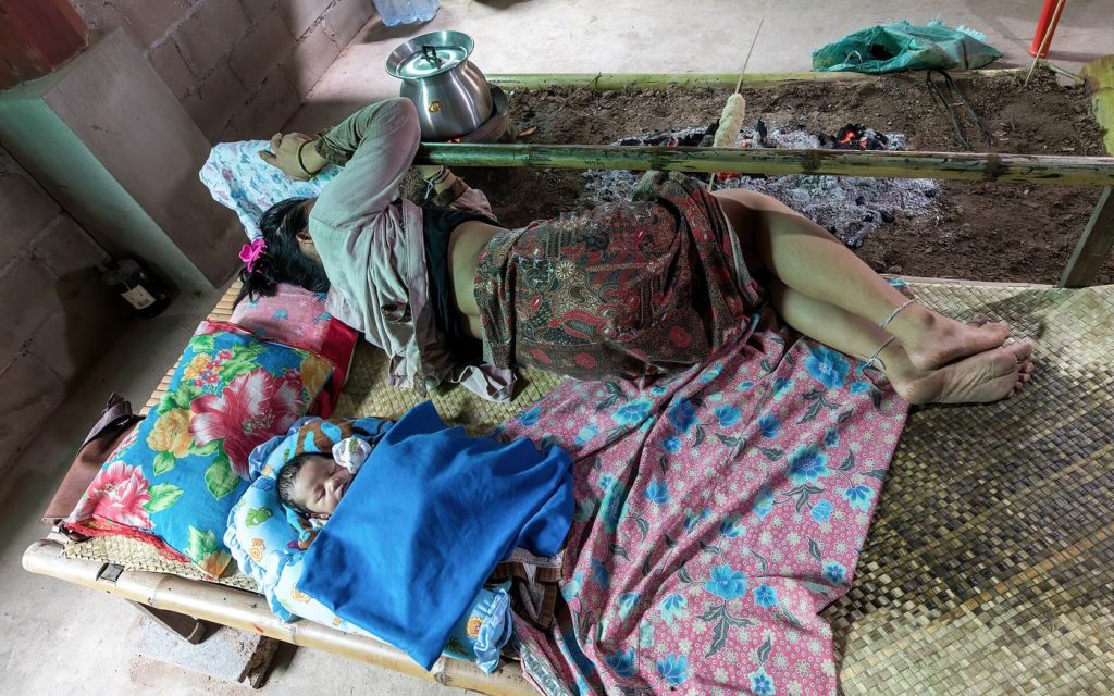 A woman asleep on a simple bed